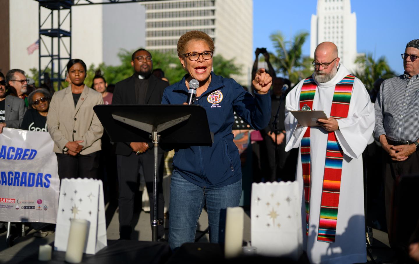 A woman stands at a podium, speaking to the crowd.